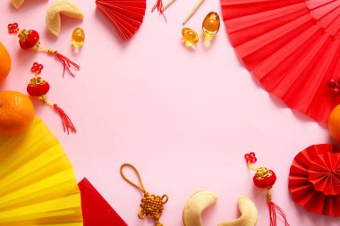 Çince sembollerden yapılmış bir çerçeve ve pembe arka planda fal kurabiyeleri. Yeni yıl kutlaması