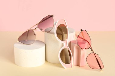 Renkli arka planda farklı stil güneş gözlüklü dekoratif podyumlar