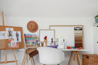 Moda tasarımcısının stüdyosunun içinde iş yeri ve çizimler var.