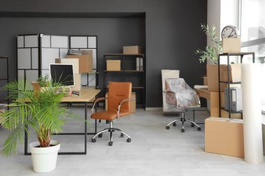 Taşındığı gün ofisinde karton kutular ve raf üniteleri olan masalar