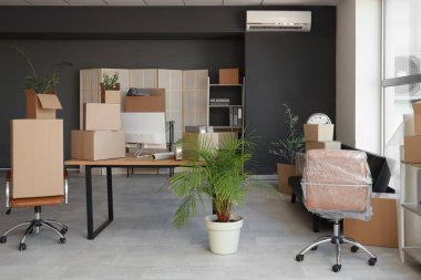 Taşınma gününde koltukları ve karton kutuları olan modern işyeri