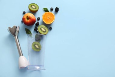 Mavi arka planda meyve ve böğürtlen ile modern blender