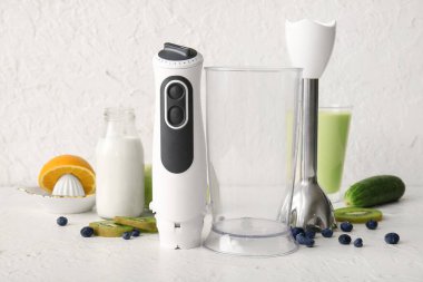 Beyaz arka planda süt, meyve ve böğürtlen ile modern blender