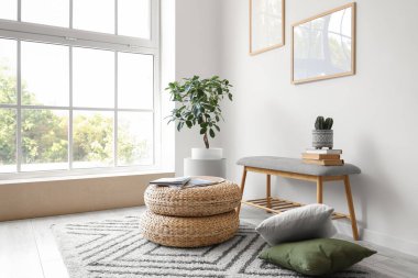 Oturma odasının içinde yumuşak banklar, puflar ve yastıklar.