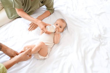 Genç ebeveynler bebeklerini sütle besliyorlar.