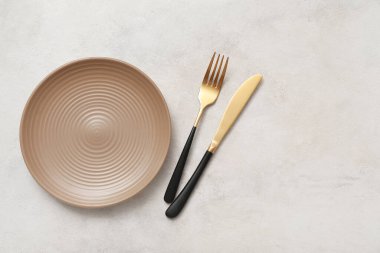 Açık arkaplanda temiz tabak ve çatal bıçak takımı
