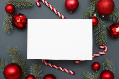 Boş kart, Noel topları, baston şekerler ve yeşil arka planda köknar dalları