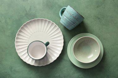 Temiz bardaklar, kase, tabak ve yeşil grunge arkaplan. Üst görünüm