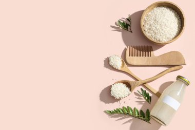 Arkaplanda pirinç suyu, tahıl ve saç tarağı bulunan kompozisyon