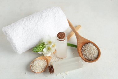 Pirinç suyu, tahıl, çiçek ve arka planda temiz havlu olan şişeler.