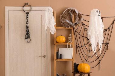 Cadılar Bayramı için salon kapısı ve raf ünitesi ile dekore edilmiş.