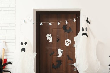 Cadılar Bayramı dekorlu ve koridorda hayaletler olan kapı.
