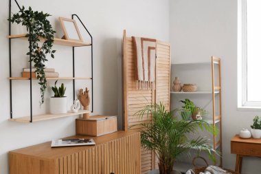 Çekmeceler, raf ünitesi ve yatak odasının iç tarafındaki çiçekli katlama ekranı.