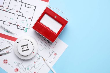 Mavi arka planda yangın çağrı noktası ve tahliye planına sahip modern duman dedektörü