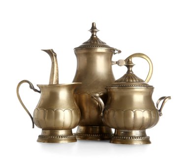 Beyaz zemin üzerinde sürahi ve şeker kasesi olan altın çaydanlık.