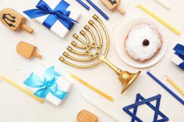 Menorah, mumlar, hediye kutuları ve beyaz grunge arkaplanlı donut ile Hanukkah kutlaması için kompozisyon