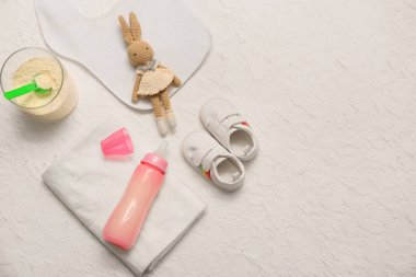 Feeding bottle, baby milk formula and accessories on light background