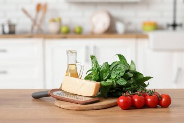 Mutfaktaki masada rende, peynir, domates ve yağ.