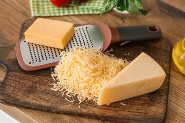 Metal rendesi, peynir ve tahta kesme tahtası mutfaktaki ahşap masa, yakın plan.