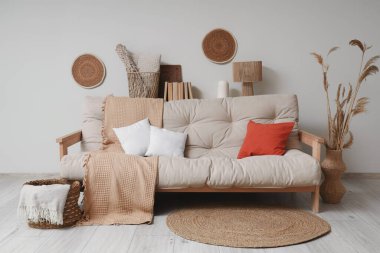 Konforlu kanepe, otlar ve salonun içinde ekoseli hasır sepet.