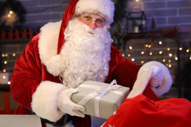 Noel Baba, Noel hediyesini postanede çantaya koyar.