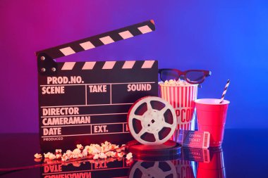 Film makaralı film alkışları, sinema bileti ve arka planda patlamış mısır.