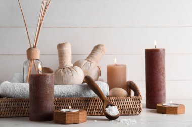 Işık arka planında mum ve spa malzemeleri yakmak