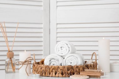 Işık arka planında yanan mumlar, havlular ve spa malzemeleri