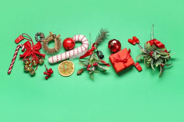 Güzel Noel süslemeleri, ökseotu dalları ve yeşil arka planda hediye kutusu olan kompozisyon