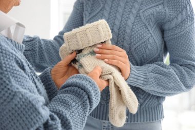 Üst düzey bir kadın, torununa evde çorap örüyor.