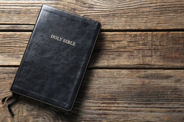 Holy Bible on wooden background clipart