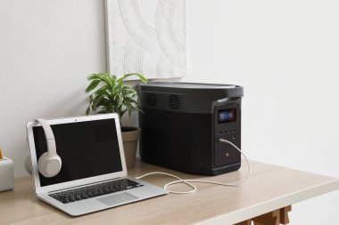 Ofisinde ışık duvarı yakınında taşınabilir elektrik santrali olan modern işyeri.