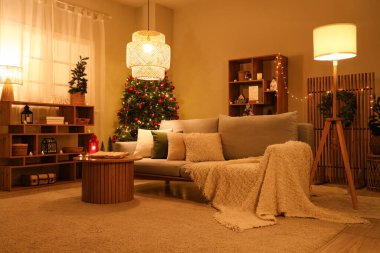İçinde kahve masası ve Noel süslemeleri açık eski bir kitap olan karanlık oturma odasının içi. Noel hikayesi konsepti