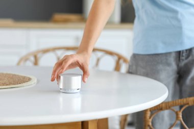 Evdeki kablosuz hoparlörlü güzel genç kadın, yakın çekim.