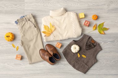 Şık çocuk kıyafetleri, ayakkabıları, küpleri ve düşmüş yaprakları olan kompozisyon