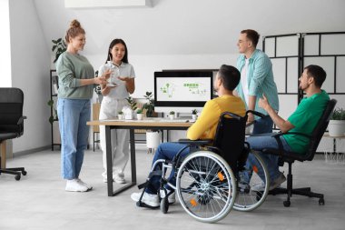 Rüzgâr türbini modelli meslektaşlar ofiste iş toplantısı yapıyorlar. Yeşil enerji kavramı