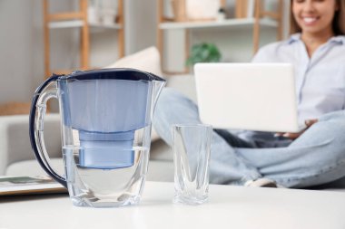 Su filtresi sürahisi ve cam masada.