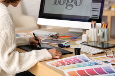 Ofisteki masada grafik tableti ve renk örnekleriyle çalışan genç bayan tasarımcı, yakın plan