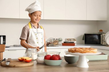 Küçük tatlı Asyalı şef mutfakta yemek pişiriyor.