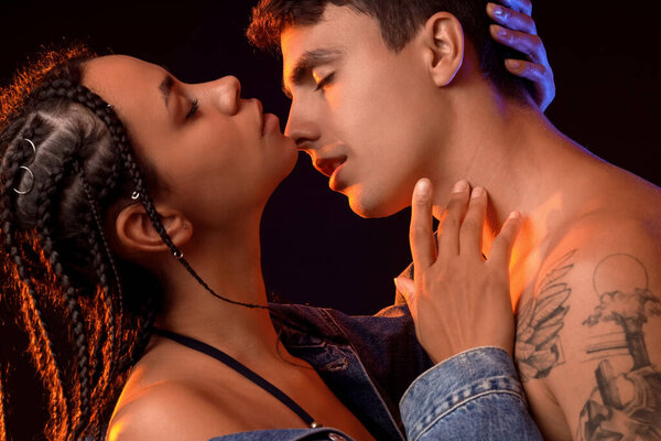 Молодая пара целуется на черном фоне, крупным планом