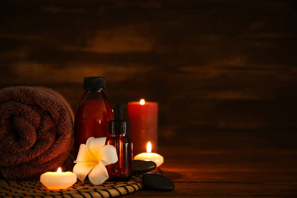Spa composition with burning candles on dark wooden table, closeup