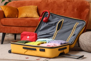 Şık kıyafetler, kulaklıklar ve odadaki ilk yardım çantasıyla.