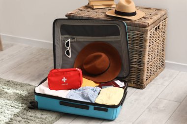 İlk yardım çantalı, şık elbiseli ve kahverengi şapkalı.