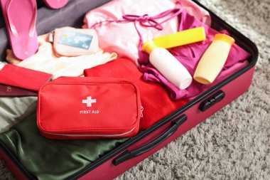 İlk yardım çantaları, şık kıyafetler ve oda için güneş kremi şişeleri.