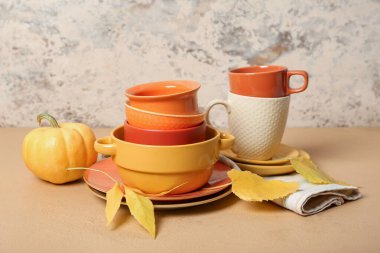 Arka planda sonbahar dekorasyonu ve balkabağı olan tabak yığını