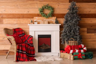 Şömine, Noel ağacı, koltuk ve ökseotu çelengi oturma odasında.