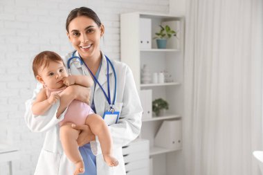 Klinikte küçük bebeği olan kadın bir çocuk doktoru.