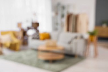 Masada elbise askısı, kanepe ve dizüstü bilgisayar olan oturma odasının bulanık görüntüsü