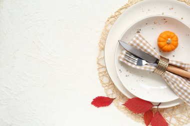 Beyaz arka planda taze balkabağı ve sonbahar yapraklarıyla güzel bir masa.