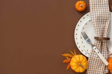 Kahverengi arka planda taze balkabaklarıyla ve sonbahar yapraklarıyla güzel bir masa.